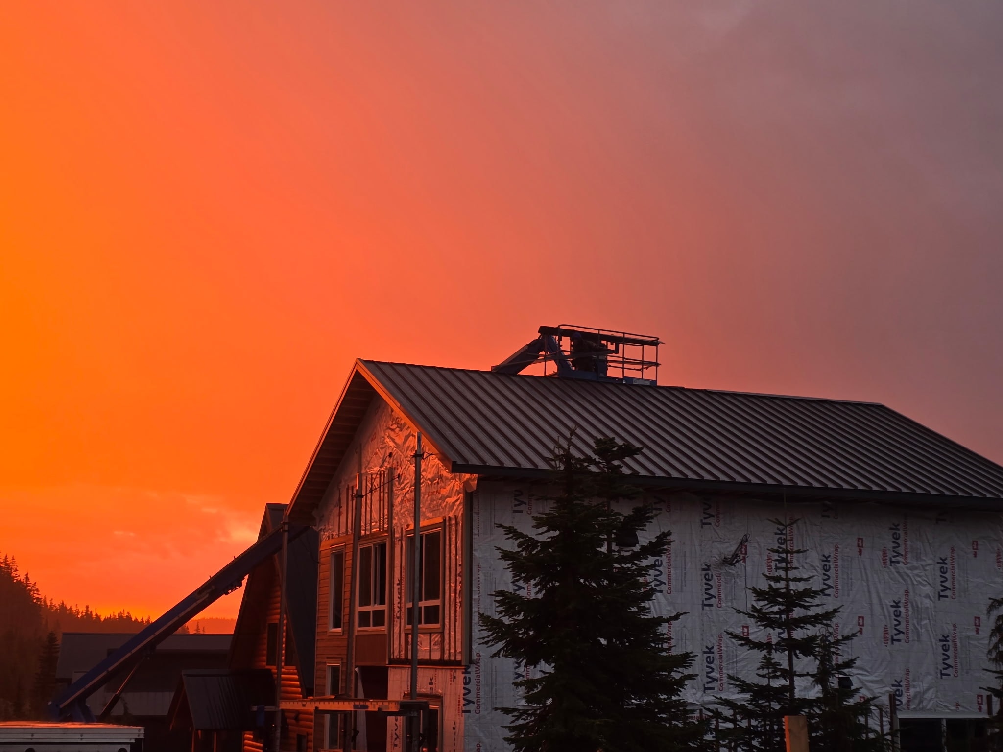 Metal roof on building under construction at dramatic orange sunset