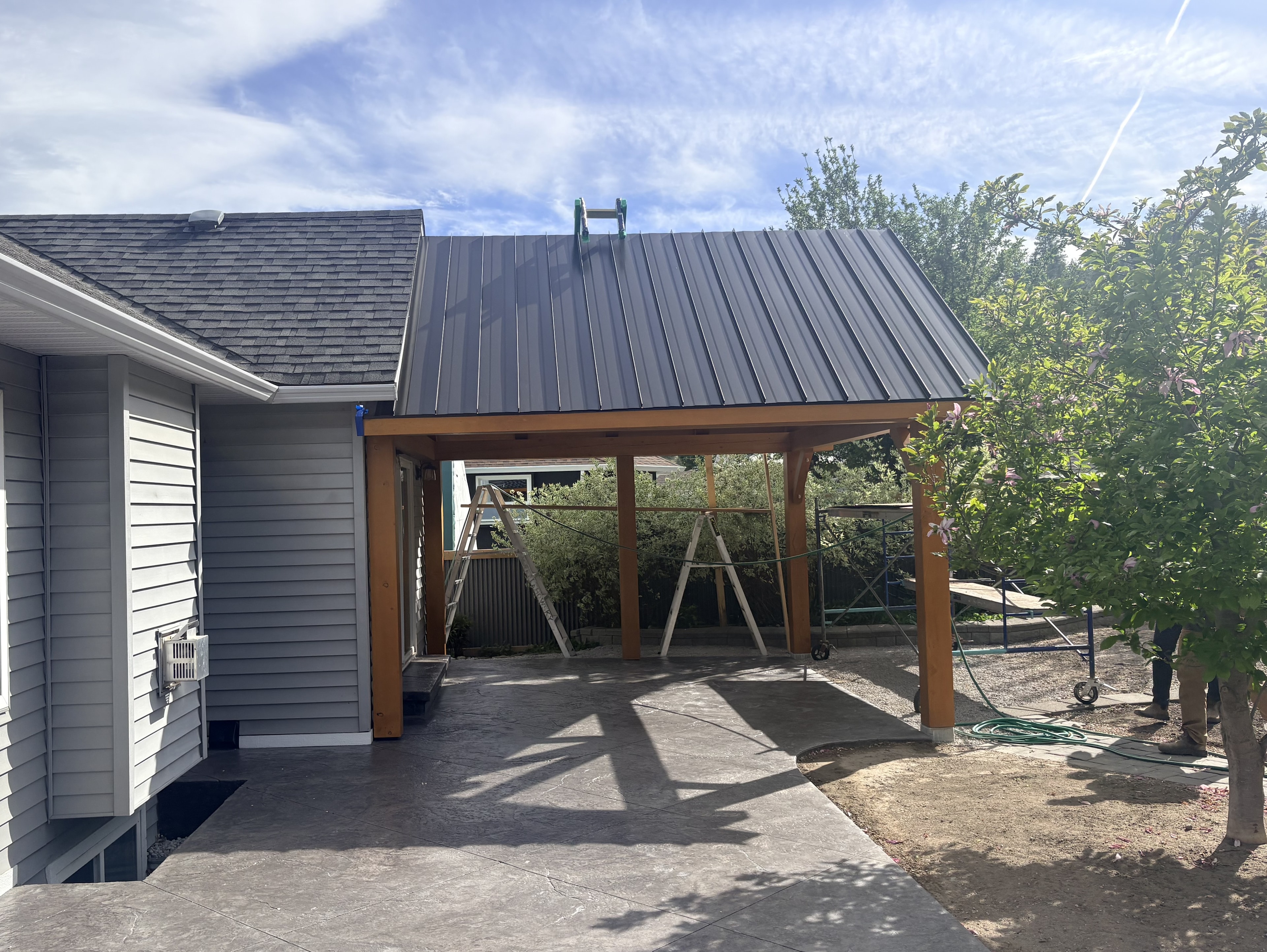 Metal roof panels stacked on site with gambrel building under construction
