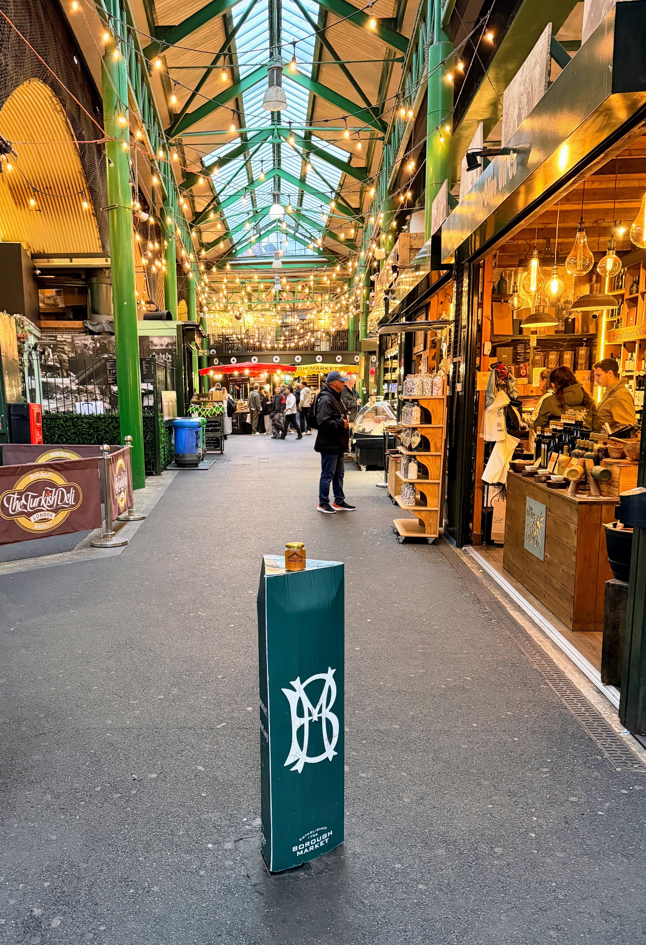 OneKEpp honey jar on a Borough Market bollard inside the bustling market hall