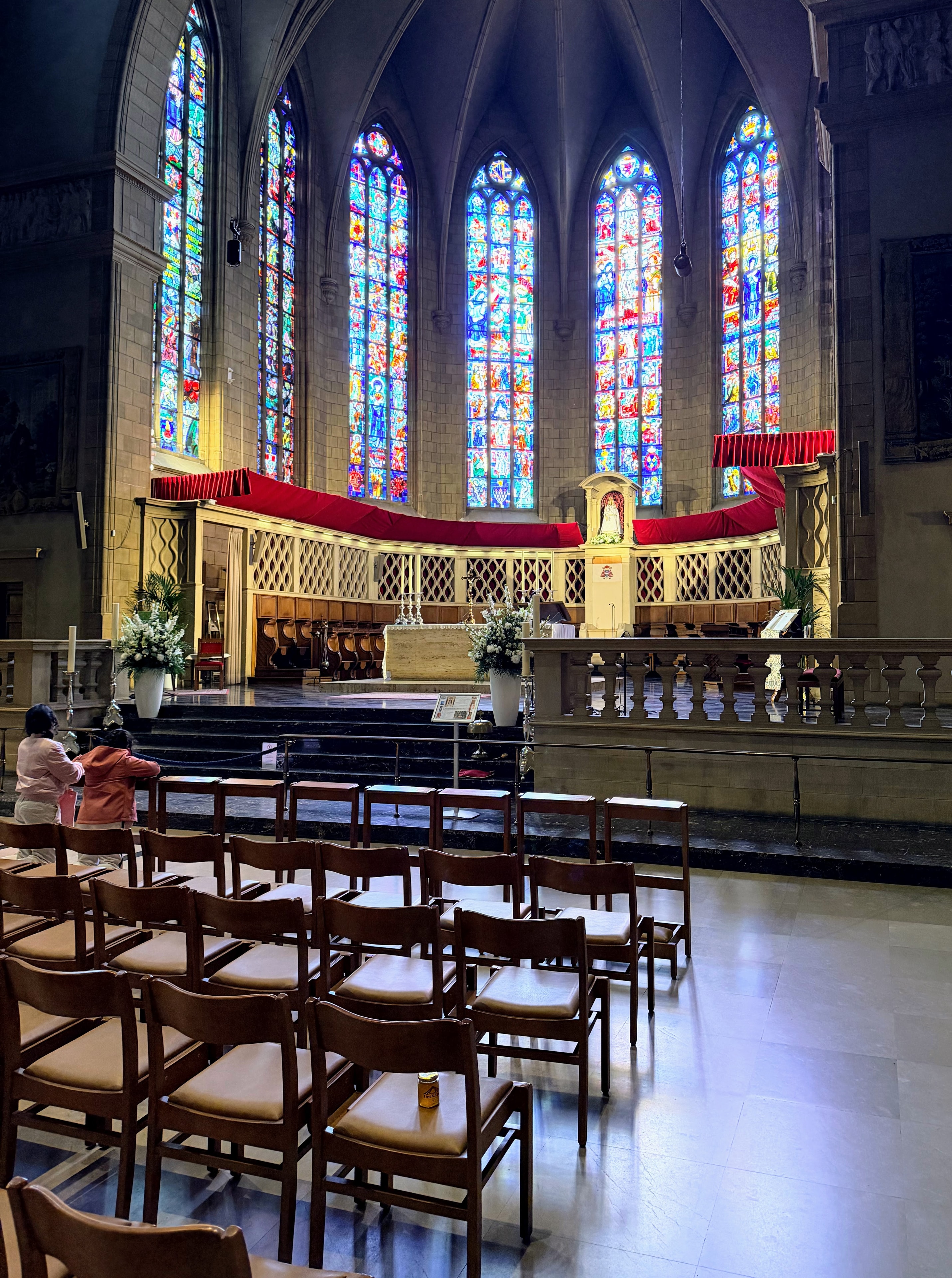 OneKEpp honey jar on a pew inside Luxembourg's Notre-Dame Cathedral with stunning stained glass windows and red draping